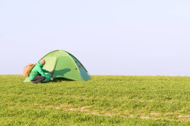 Yaz tarlasında çadırına yakın elleri havada turist