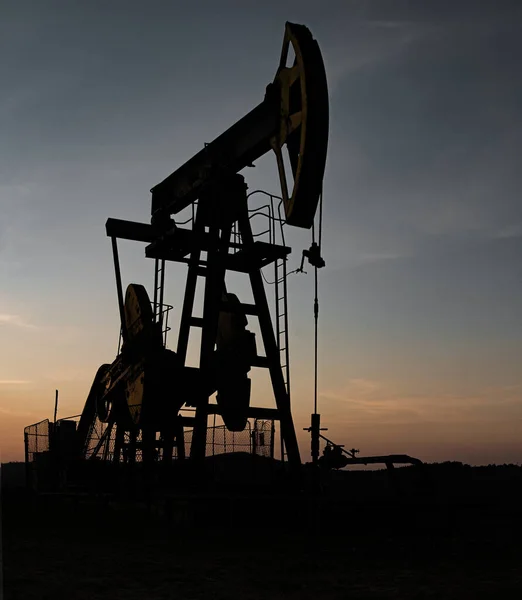 石油ポンプオイルリグ設計のための日没の背景に石油のエネルギー産業機械 — ストック写真