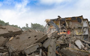 Eski binanın sökülme işlemleri devam ediyor. Kazıcı evi yıkıyor. Yeni gelişmeler için harap olmuş konutların tahrip edilmesi