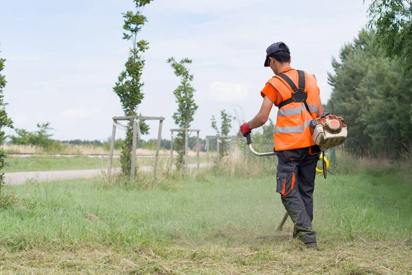 Arbeiter Mäht Gras Garten Mit Dem Unkrautschneider — Stockfoto