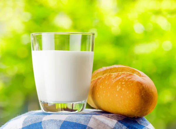 Leite fresco e pão no fundo da natureza — Fotografia de Stock