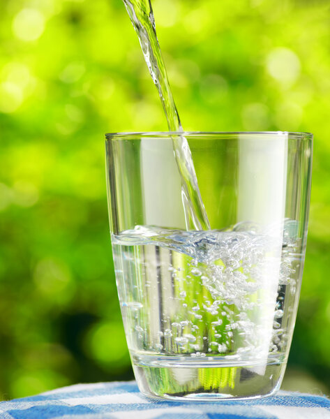 Glass of water on nature background