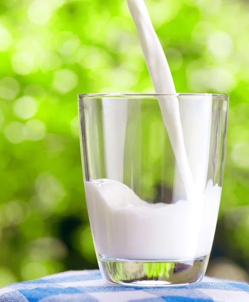 Bicchiere di latte su sfondo naturale — Foto Stock