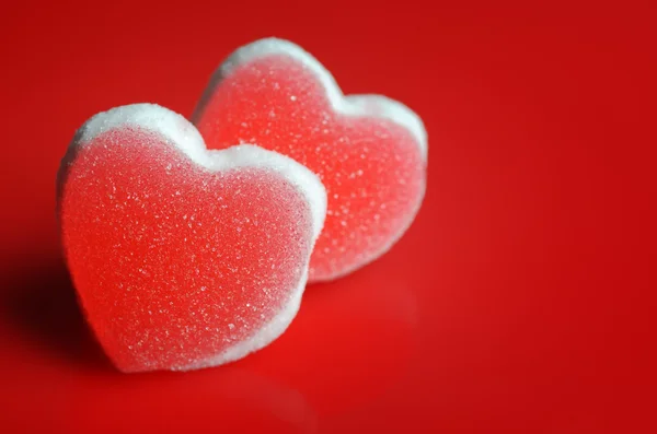 Şeker kalpler kırmızı zemin üzerine — Stok fotoğraf