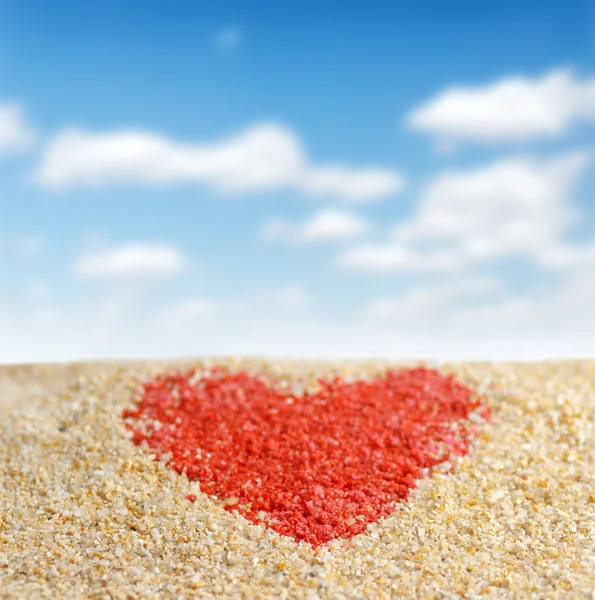 Red heart sign in yellow sand — Stockfoto