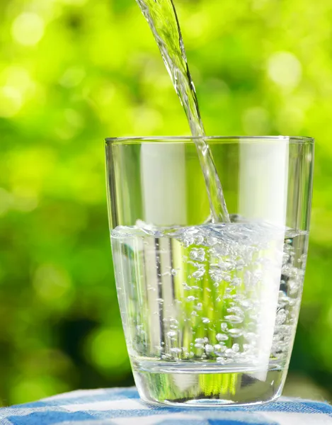 Glas Wasser auf Naturhintergrund — Stockfoto