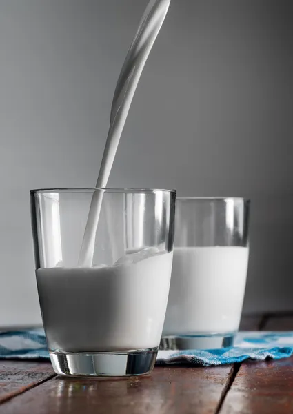 Vaso de leche de vaca sobre la mesa — Foto de Stock