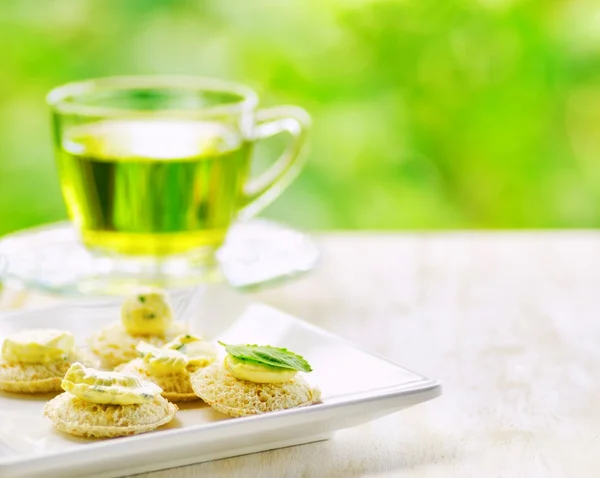 Mehrere Kanapees und eine Tasse Kräutertee. — Stockfoto