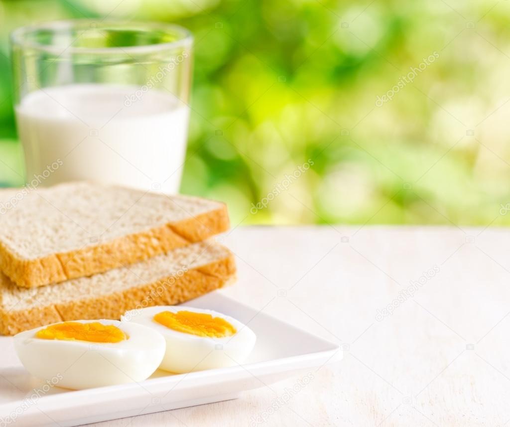 Boiled eggs, toasts and glass of milk