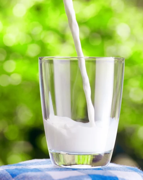 Ποτήρι γάλακτος στο φόντο της φύσης — Φωτογραφία Αρχείου