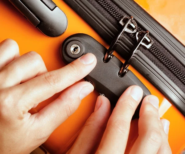 Woman locked her luggage in the orange suitcase — Stock Photo, Image