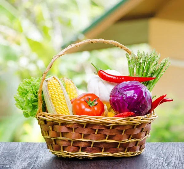 Verdure fresche nel cesto sul tavolo di legno — Foto Stock