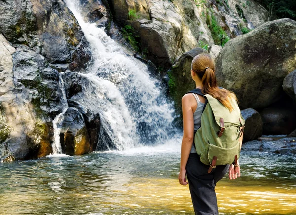 Vrouwelijke wandelaar kijken naar waterval — Stockfoto