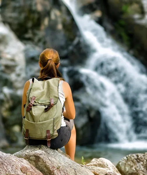 Vrouwelijke wandelaar kijken naar waterval — Stockfoto