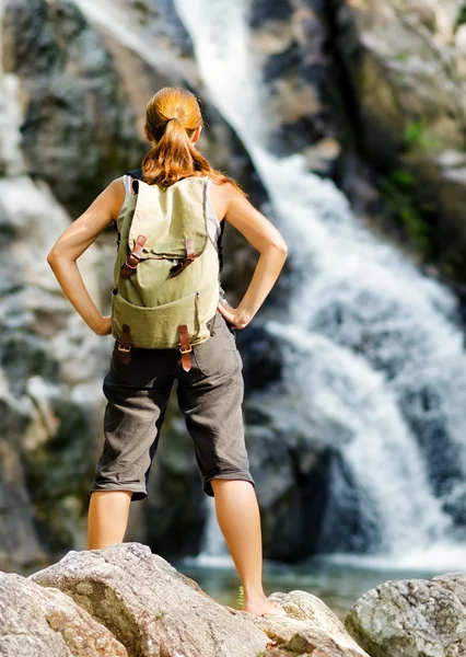 Caminhante feminina olhando para cachoeira — Fotografia de Stock