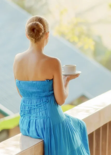 朝のテラスでコーヒーを飲む若い女性 — ストック写真