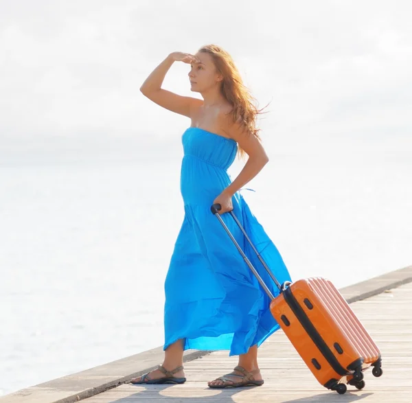 Jonge vrouw met koffer op de pier — Stockfoto