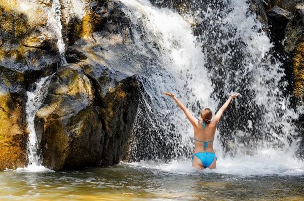 Ung kvinna avkopplande i vattenfall — Stockfoto