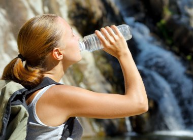 genç bir kadın tarafından şelale suyu içer