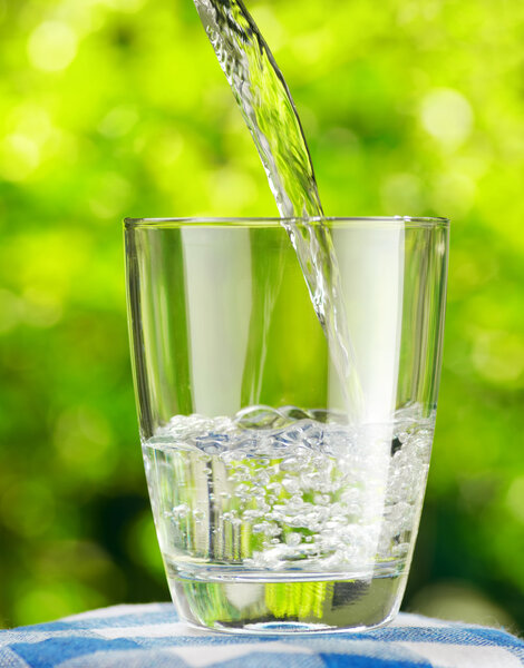 Glass of water on nature background