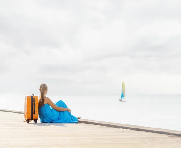 Jonge vrouw zittend op houten pier — Stockfoto