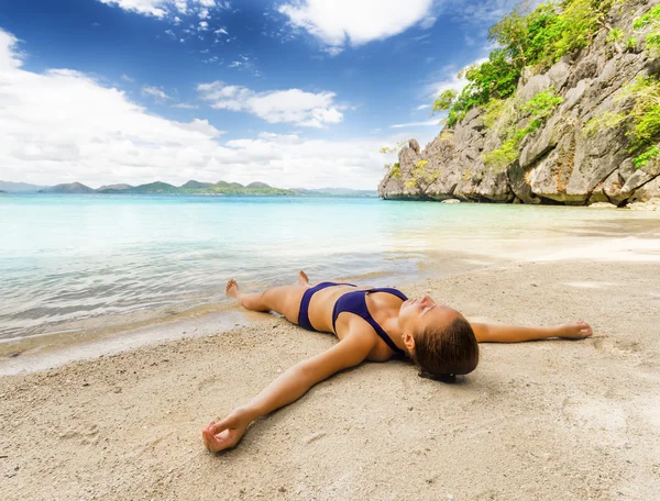 Junge schöne Frau entspannt sich auf Sand am Meer — Stockfoto