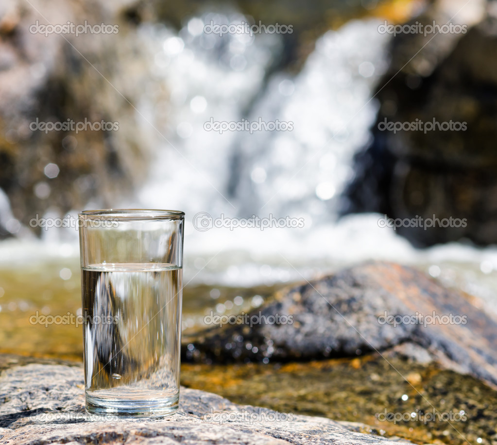 Glass of water by waterfall