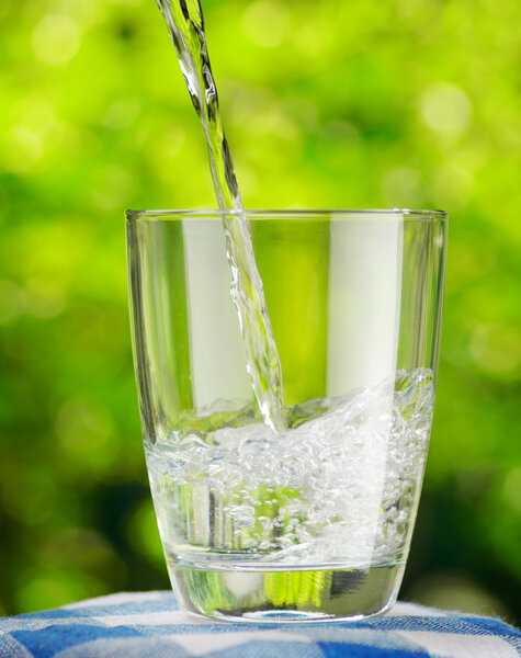 Glass of water on nature background