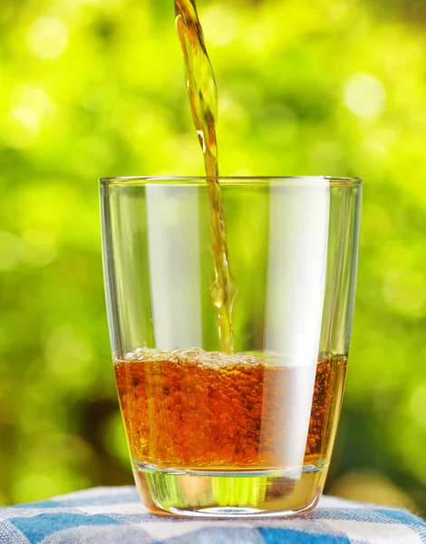 Vidro de suco de maçã no fundo da natureza — Fotografia de Stock