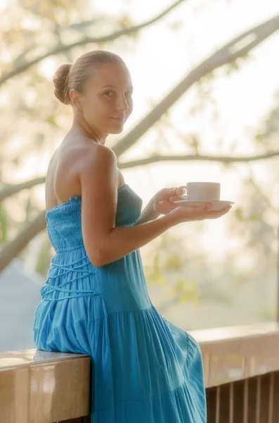 朝のテラスでコーヒーを飲む若い女性 — ストック写真