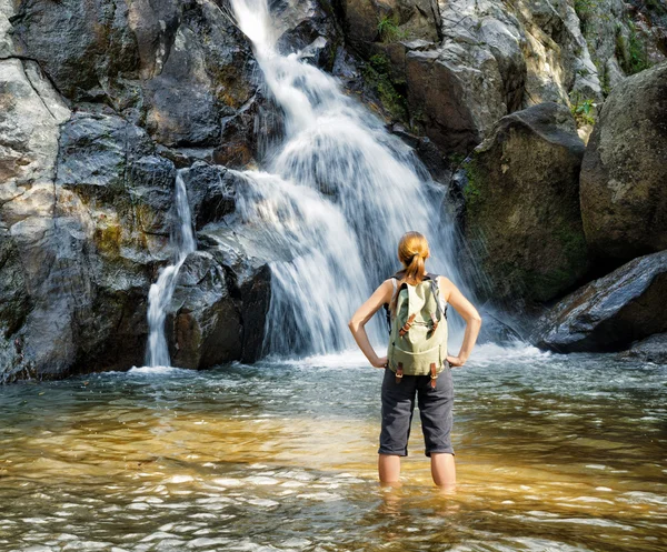 Wanderin blickt auf Wasserfall — Stockfoto