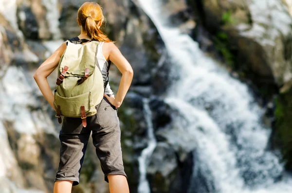 Escursionista femminile guardando cascata — Foto Stock