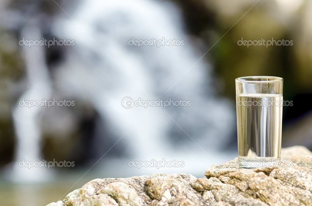 Glass of water by waterfall