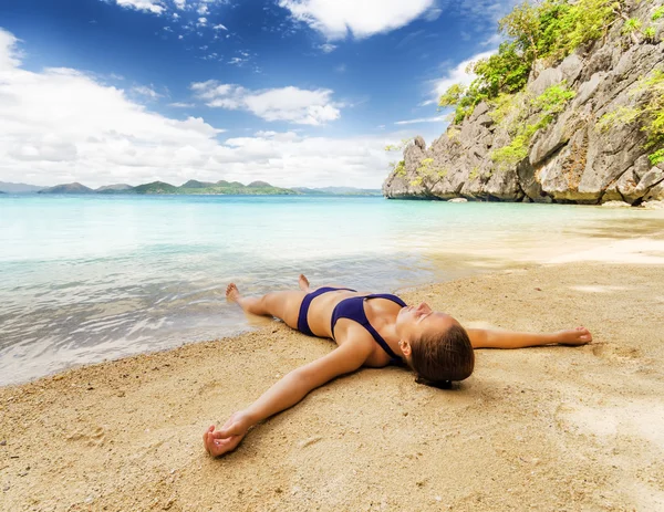 Junge schöne Frau entspannt sich auf Sand am Meer — Stockfoto