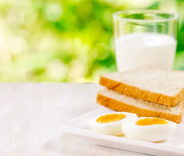 Boiled eggs, toasts and glass of milk — Stock Photo, Image