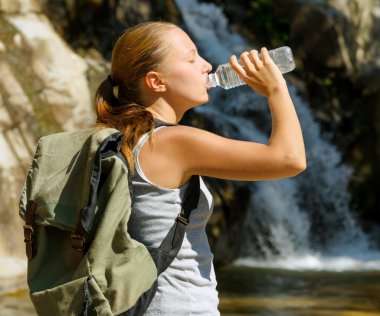 genç bir kadın tarafından şelale suyu içer