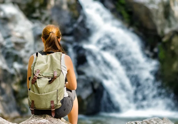 Wanderin blickt auf Wasserfall — Stockfoto