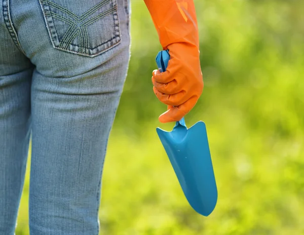 Vrouw in oranje handschoenen werken in de tuin — Stockfoto