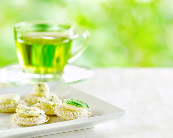 Mehrere Kanapees und eine Tasse Kräutertee. — Stockfoto