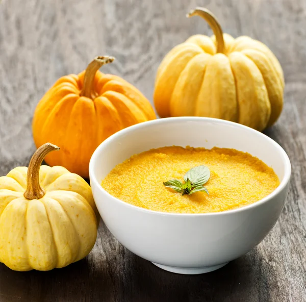 Porridge di zucca e zucche su tavolo di legno nero — Foto Stock