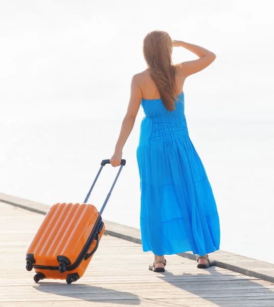 Jonge vrouw met koffer op de pier — Stockfoto