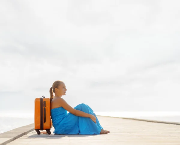 Ahşap iskele üzerinde oturan genç kadın Telifsiz Stok Imajlar