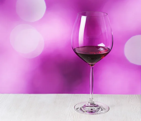 Glass of red wine on purple background — Stock Photo, Image