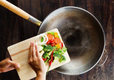 kesme tahtası üzerinde taze sebze wok içinde düşer. co
