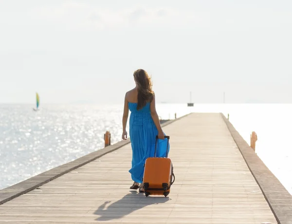 Mujer joven caminando sobre muelle de madera — Foto de Stock