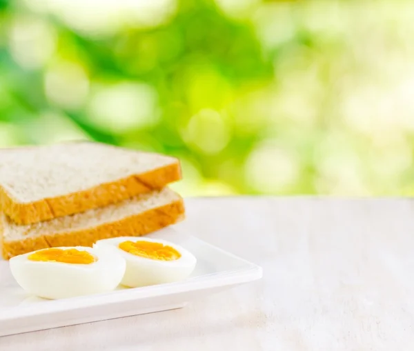 Gekochte Eier und Toast auf weißem Tisch — Stockfoto