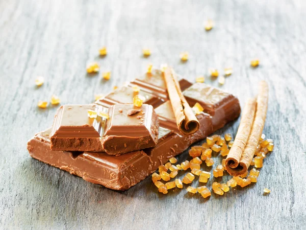 Gebrochene Schokolade auf Holztisch — Stockfoto