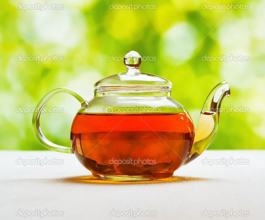 Teapot of fresh tea on natural background
