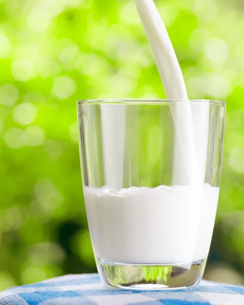 Bicchiere di latte su sfondo naturale — Foto Stock