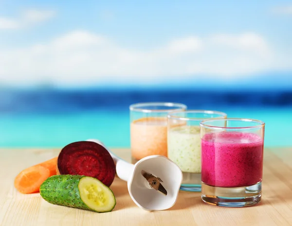 Smoothie vegetal na mesa de madeira no fundo da praia — Fotografia de Stock